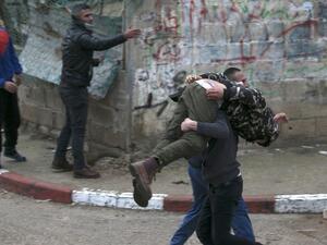 Palestinian youths evacuate a wounded comrade during clashes with Israeli forces in Jenin, in the north of the occupied West Bank, on Jan. 18, 2018 (JAAFAR ASHTIYEH / AFP)