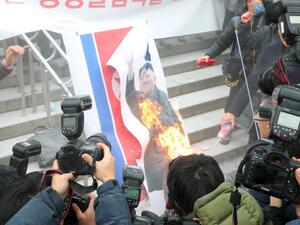 South Korean protesters burn a picture of North Korean leader Kim Jong-Un during an anti-North Korea rally outside Seoul station in Seoul on Jan. 22, 2018, as a North Korean delegation arrives at the station (Dong-A Ilbo / AFP)