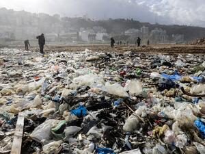 Workers clean the beach of the coastal town of Zouk Mosbeh, north of Beirut, on Jan. 23, 2018 as garbage washed and piled along the shore after stormy weather (JOSEPH EID / AFP)