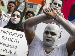 African migrants demonstrate with white paint on their faces and with their hands crossed, outside the Embassy of Rwanda in the Israeli city of Herzliya on Feb. 7, 2018 (JACK GUEZ / AFP)