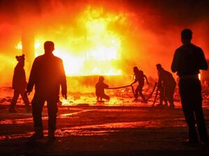 A picture taken on Feb. 7, 2018 shows Syrian civil defense volunteers attempting to put out a fire in the city of Maaret al-Numan in the rebel-held Idlib province, following reported regime air strikes (Amer ALHAMWE / AFP)