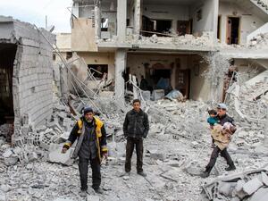 Syrian civil defense volunteers stand amid debris and destruction following a reported regime airstrike in the besieged town of Douma in the Eastern Ghouta region, on the outskirts of the capital Damascus, on Feb.15, 2018. 
(Hamza Al-Ajweh / AFP)