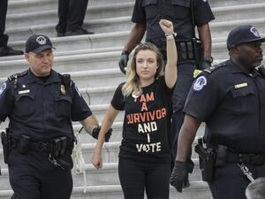 A protestor is arrested as demonstrators occupy the steps on the East Front of the U.S. Capitol in protest of Supreme Court nominee Judge Brett Kavanaugh, October 6, 2018 in Washington, DC (AFP)
