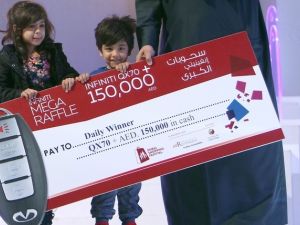 Three-year-old Talal Al Hammar accepts his reward for winning the Dubai Shopping Festival raffle. (Twitter) 