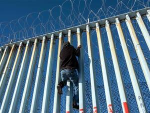 A Central American migrant that hopes to reach the United States, climbs the US-Mexico border fence in Playas de Tijuana, Baja California State, Mexico. (AFP/ File)