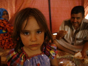 An Iraqi family poses for a photo in a tent at a makeshift camp for internally displaced persons (AFP/File Photo)