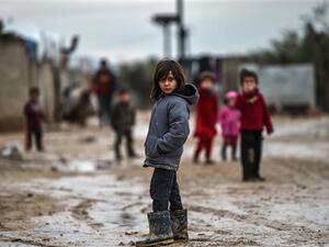 Children stand in a muddy street at a refugee camp on Jan. 26, 2018 at the Syrian town of Azaz (AFP)