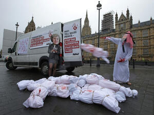 Demonstrators wearing masks depicting Britain's Prime Minister Theresa May and Saudi Arabia's Crown Prince Mohammed bin Salman (AFP/File Photo)