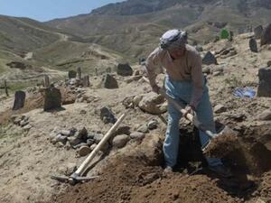 An Afghan man digs a grave for one of the 57 victims of a bomb blast before the burial, a day after the attack on a voter registration center in Kabul. (AFP/ File Photo)
