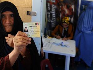 An elderly woman displays her identification card to vote in Afghanistan's forthcoming presidential election at a registration center in Herat.(AFP/File)