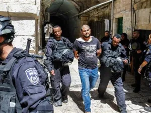 Members of Israeli security forces take into custody a Palestinian protester after clashes at the Aqsa Mosque compound on July 27, 2018. (AFP)