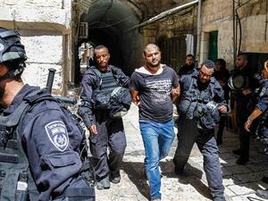 Members of Israeli security forces take into custody a Palestinian protester after clashes at the Aqsa Mosque compound on July 27, 2018. (AFP)