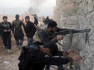 Syrian rebel fighters shoot through a hole in a wall towards forces loyal to the regime in Aleppo.(AFP / File)

