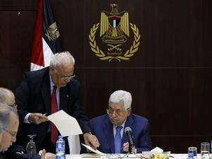 Palestinian president Mahmoud Abbas (R) speaks with Palestine Liberation Organization's Secretary General Saeb Erekat during a meeting of the Palestine Liberation Organization (PLO) (AFP)
