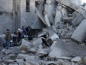 A picture taken on March 26, 2019, shows Palestinians walking amidst next to the rubble of a building in Gaza City, after Israeli air strikes hit dozens of sites across the Strip overnight in response to rocket fire from the Palestinian enclave (AFP)