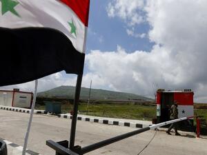 A member of the Syrian security forces walks near the border post with Israel in the Syrian town of Quneitra in the Golan Heights  (AFP)