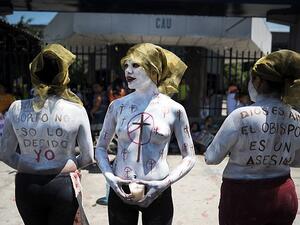 Imelda Cortez, 20, is facing 20 years in jail after she was charged with attempted murder for giving birth to her abuser's baby in a toilet in El Salvador. Pictured: Members of a feminist organisation demonstrate in favour of abortion rights outside the Courthouse of San Salvador  (AFP)