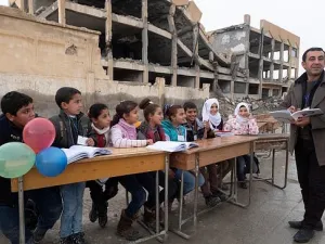 Haunted by the past: A bombed building used as an Isis prison is the backdrop to head Ibrahim Ismail’s talk with pupils (dailymail)