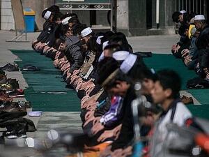 Ethnic Hui Muslim men praying at Nanguan Mosque during Friday prayers in Linxia, Gansu (AFP)