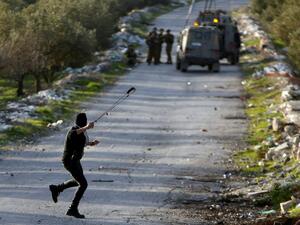 A Palestinian protester uses a sling to hurl stones towards Israeli troops (Twitter)