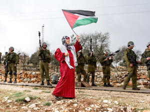 Palestinian woman walks with Palestinian flag (Shutterstock)	 Palestinian woman walks with Palestinian flag (Shutterstock)