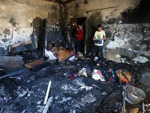 People survey the remains of the firebombed Dawabsha home in 2015. (AFP/File)
