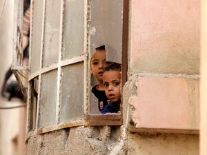Palestinian children in al-Fawwar refugee camp watch the Israeli raids through their window. (AFP/File)
