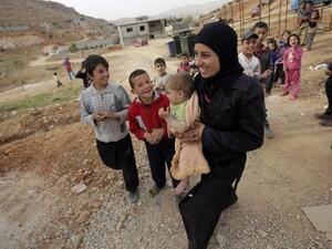 A Syrian mother and her children walk through their refugee camp in Arsal, Lebanon. (AFP/File)