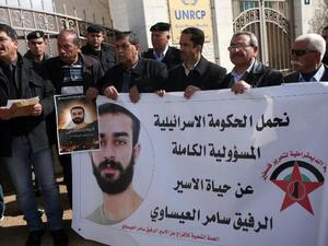 Palestinian protesters hold placards during a demonstration in Ramallah in support with Palestinian prisoners held in Israeli jails, some of whom are observing a hunger strike. (AFP PHOTO/ABBAS MOMANI)
