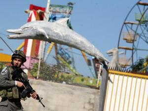 An Israeli soldier stands guard in front of an amusement park during a military operation carried out to arrest Palestinian militants in the West Bank city of Jenin on Sunday. (AFP PHOTO/SAIF DAHLAH)