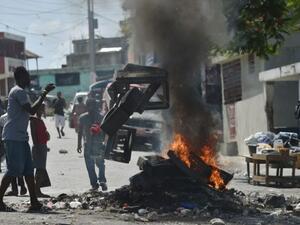 Demonstrator throws plastics onto a smouldering barricade in central Port-au-Prince, July 9, 2018, following two days of deadly looting and arson triggered by a quickly-aborted government attempt to raise fuel prices. (AFP/ File Photo)