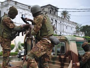 Malian soldiers stand guard outside the presidential palace. (AFP) 