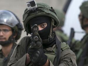 Israeli soldier aims his weapon at Palestinians. (AFP/File)