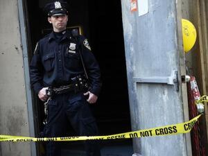 A NYPD officer stands in front of the New York building where a piece of airplane, believed to belong to one of those hijacked on 9/11, was found twelve years on. AFP photo