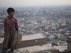 Afghan shoe-shine boy looks on from a hillside as he waits for customers in Kabul. (AFP)