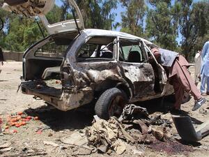 Afghan residents gather at the scene of a suicide car bomb that targeted a CIA-funded pro-government militia force at a public bus station in Khost province on May 27, 2017. (Farid Zahir/AFP)