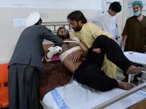 A victim is helped by relatives at a hospital after eight people were killed and 45 wounded in a series of explosions targeting a cricket match in the eastern Afghan city of Jalalabad. (AFP/ File Photo)