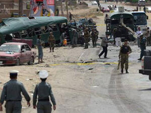 Afghan security personnel gather near the wreckage of buses which were carrying police cadets, at the site of a bomb attack on the outskirts of Kabul on June 30, 2016. (AFP)