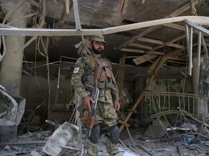 A Afghan security personnel keeps watch at the site of a suicide attack outside a bank near the US embassy in Kabul on August 29, 2017 (AFP)