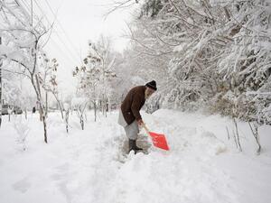 An elderly Afghan man shovels snow in Kabul on February 5, 2017. (AFP/Shah Marai)