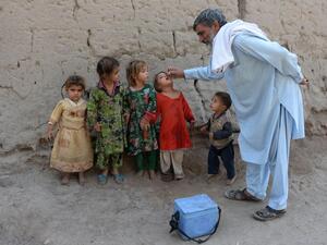 An Afghan health worker administers the polio vaccine to a child during a campaign on the outskirts of Jalalabad on October 17, 2016. (AFP/Noorullah Shirzada)