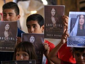 أطفال ايزيديون يحملون صور نادية مراد، التي فازت بجائزة نوبل للسلام