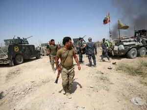 Iraqi government forces gather next to their vehicles during an operation to retake the area from Daesh on June 15, 2016 in Fallujah's southern Shuhada neighbourhood (AFP/Ahmad Al-Rubaye)