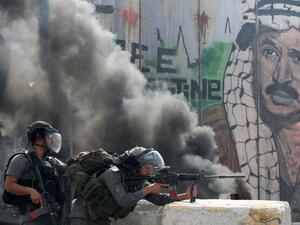 Israeli soldiers clash with Palestinian stone throwers at a checkpoint outside Jerusalem (AFP/Getty Images/ Ahmad Gharabli)