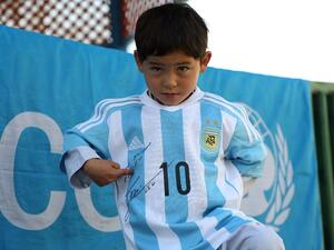 Afghan boy Murtaza Ahmadi proudly wears one of the jerseys sent by his idol Lionel Messi. (AFP/Mahdy Mehraeen)