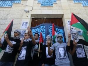 Palestinian youths wait outside the United Nations Development Programme (UNDP) offices during a 2015 rally in Gaza City. (AFP/File) 
