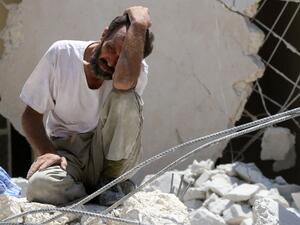 A man pictured in the rubble of a collapsed building following reported air strikes in Aleppo, northern Syria, on July 17, 2016 (AFP/Thaer Mohammed)