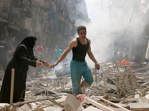 People walk amid the rubble of destroyed buildings in Aleppo. (AFP/File) 
