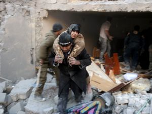 A man carries a woman from the rubble of a building following reported airstrikes on Aleppo's rebel-held district of al-Hamra on November 20, 2016. (AFP/Thaer Mohammed)