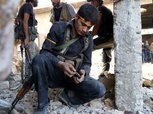 A rebel fighter reloads his weapon during clasahes with regime forces in Ramussa on the southwestern edges of Aleppo on August 6, 2016. (AFP/Fadi A-Halabi)